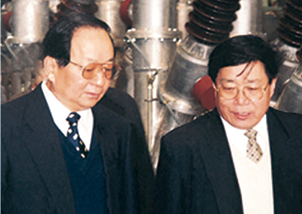 时任中 央政治局委员、全国人大副委员长田纪云(左)来企业视察